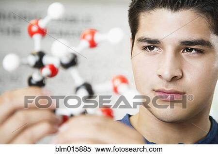 Stock Photography - Hispanic student looking at chemistry model. Fotosearch