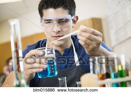 Hispanic student working with chemicals in classroom View Large Photo Image Stock Photograph - Hispanic student working with chemicals in classroom. Fotosearch