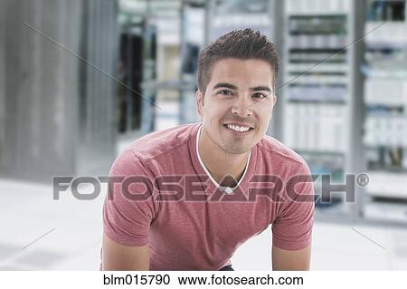 Stock Image - Mixed race businessman in server room. Fotosearch