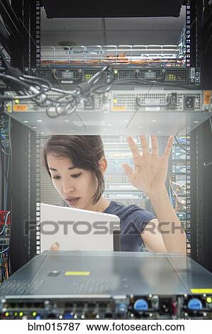 Stock Photo - Mixed race businesswoman working in server room. Fotosearch