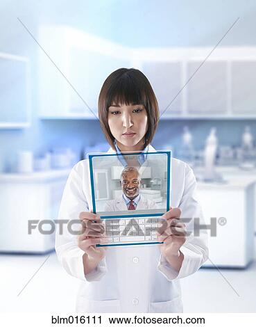Mixed race doctor using digital tablet in doctor's office View Large Photo Image Stock Image - Mixed race doctor using digital tablet in doctor's office. Fotosearch