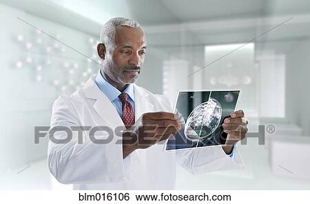Stock Photograph - Mixed race doctor using digital tablet. Fotosearch