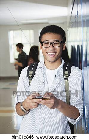 Mixed race high school student text messaging on cell phone View Large Photo Image Stock Photograph - Mixed race high school student text messaging on cell phone. Fotosearch