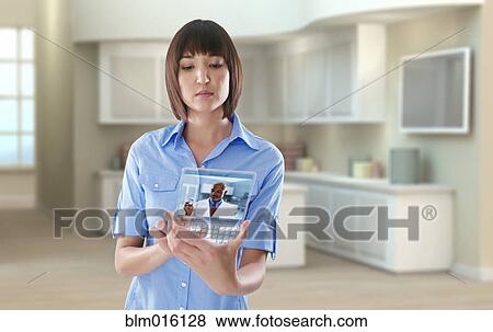Stock Photo - Mixed race woman using digital tablet in office. Fotosearch
