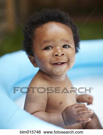 Stock Photograph - Smiling African American baby in swimming pool. Fotosearch