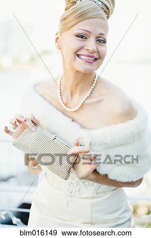 Smiling Hispanic bride holding purse View Large Photo Image Stock Photo - Smiling Hispanic bride holding purse. Fotosearch