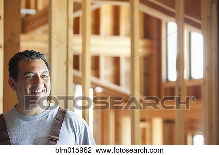 Smiling Hispanic construction worker in unfinished room View Large Photo Image Stock Image - Smiling Hispanic construction worker in unfinished room. Fotosearch