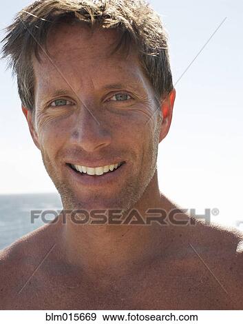 Smiling man at beach View Large Photo Image Stock Photo - Smiling man at beach. Fotosearch