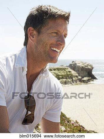 Picture - Smiling man enjoying beach. Fotosearch