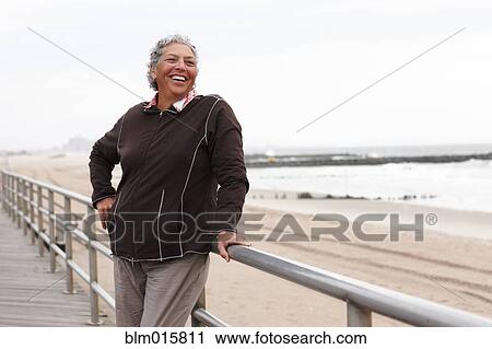 Stock Image - Smiling woman enjoying boardwalk. Fotosearch