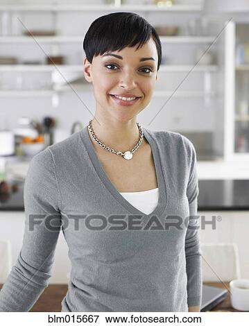 Smiling woman standing in kitchen View Large Photo Image Stock Photo - Smiling woman standing in kitchen. Fotosearch