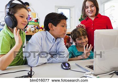Stock Photo - Students using laptop together. Fotosearch
