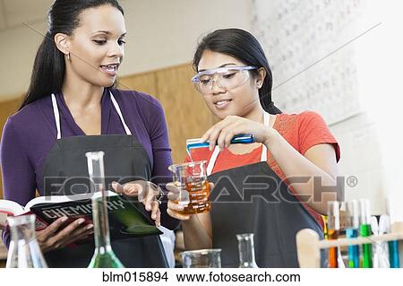 Picture - Teacher and student working with chemicals in classroom. Fotosearch