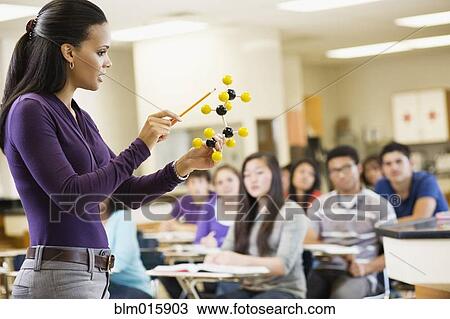 Stock Image - Teacher explaining chemistry model to classroom. Fotosearch