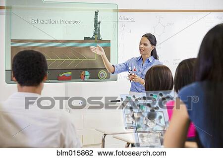 Stock Image - Teacher explaining extraction process to students in classroom. Fotosearch