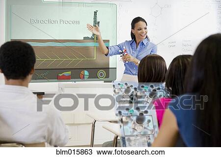 Stock Image - Teacher explaining extraction process to students in classroom. Fotosearch