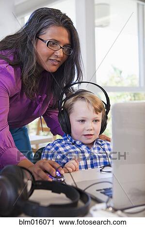 Teacher helping student using laptop in classroom View Large Photo Image Stock Image - Teacher helping student using laptop in classroom. Fotosearch
