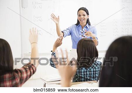 Stock Photo - Teacher talking to students in classroom. Fotosearch