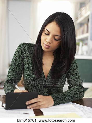 Stock Image - Woman writing in checkbook. Fotosearch