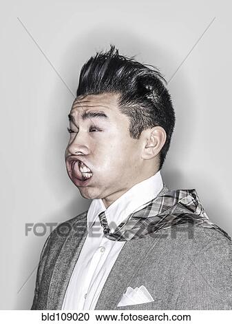 Stock Image - Businessman making face in wind. Fotosearch