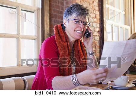 Stock Image - Caucasian businesswoman on phone in cafe. Fotosearch