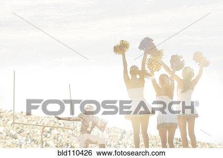 Stock Photograph - Caucasian cheerleaders on sidelines at football game. Fotosearch