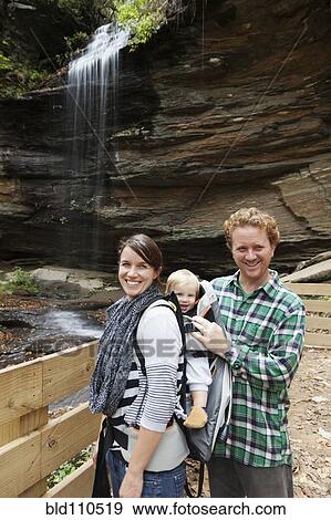 Stock Photo - Caucasian family smiling by waterfall. Fotosearch