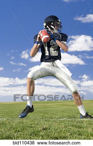 Stock Photo - Caucasian football player poised on field. Fotosearch