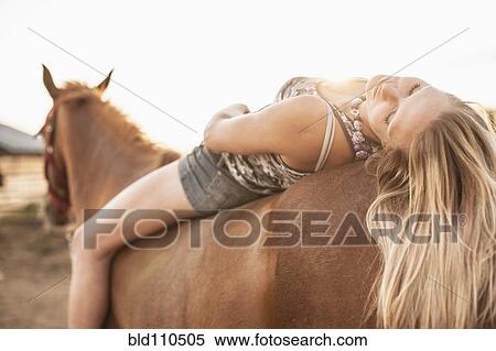 Caucasian girl laying on horse View Large Photo Image Stock Photography - Caucasian girl laying on horse. Fotosearch