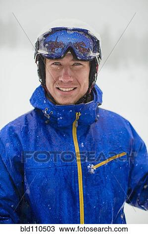 Stock Image - Caucasian man wearing ski gear in snow. Fotosearch