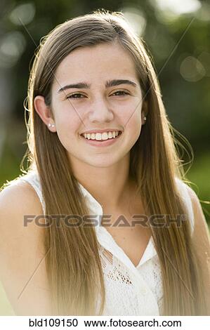 Stock Image - Caucasian teenage girl smiling outdoors. Fotosearch