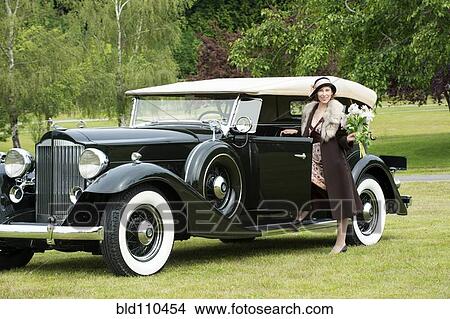 Picture - Caucasian woman by vintage car. Fotosearch