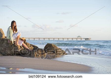 Picture - Caucasian woman sitting on beach. Fotosearch