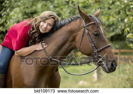 Stock Image - Caucasian woman sitting on horse outdoors. Fotosearch