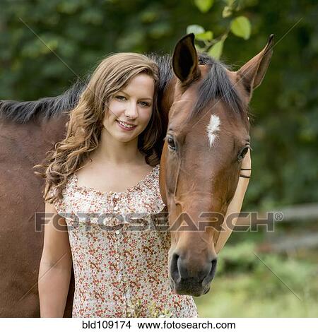 Picture - Caucasian woman walking horse outdoors. Fotosearch