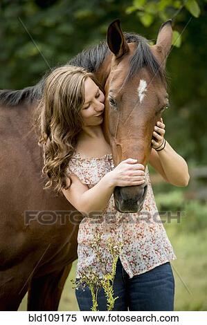 Stock Photography - Caucasian woman walking horse outdoors. Fotosearch