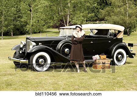 Caucasian woman with luggage by vintage car View Large Photo Image Stock Photograph - Caucasian woman with luggage by vintage car. Fotosearch