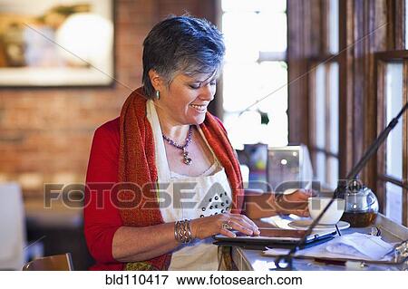 Stock Photo - Caucasian woman working in coffee shop. Fotosearch