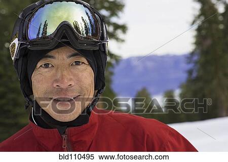 Stock Photography - Chinese man wearing ski gear in snow. Fotosearch
