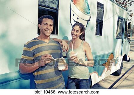 Stock Photograph - Couple eating ice cream from truck. Fotosearch