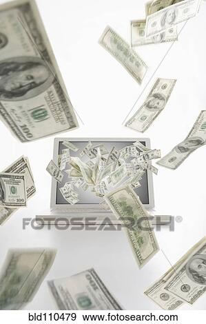 Stock Photo - Dollar bills flying from laptop computer. Fotosearch