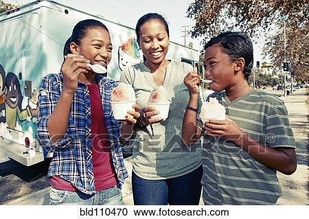 Stock Image - Family eating ice cream from truck. Fotosearch