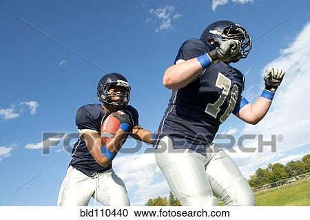 Stock Image - Football players passing ball. Fotosearch