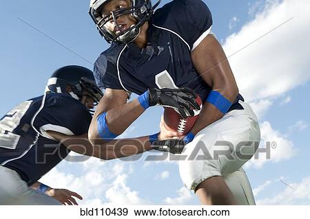 Stock Photo - Football players passing ball. Fotosearch