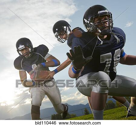 Stock Photograph - Football players passing ball. Fotosearch