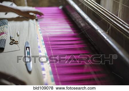 Stock Photo - Hand feeling threads in loom. Fotosearch