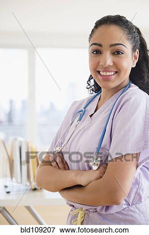 Hispanic nurse smiling in hospital View Large Photo Image Stock Photo - Hispanic nurse smiling in hospital. Fotosearch
