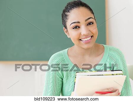 Stock Image - Hispanic student carrying books. Fotosearch
