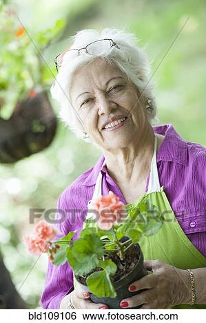 Hispanic woman gardening outdoors View Large Photo Image Stock Photograph - Hispanic woman gardening outdoors. Fotosearch