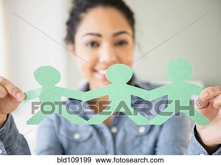 Hispanic woman holding paper dolls View Large Photo Image Stock Photo - Hispanic woman holding paper dolls. Fotosearch
